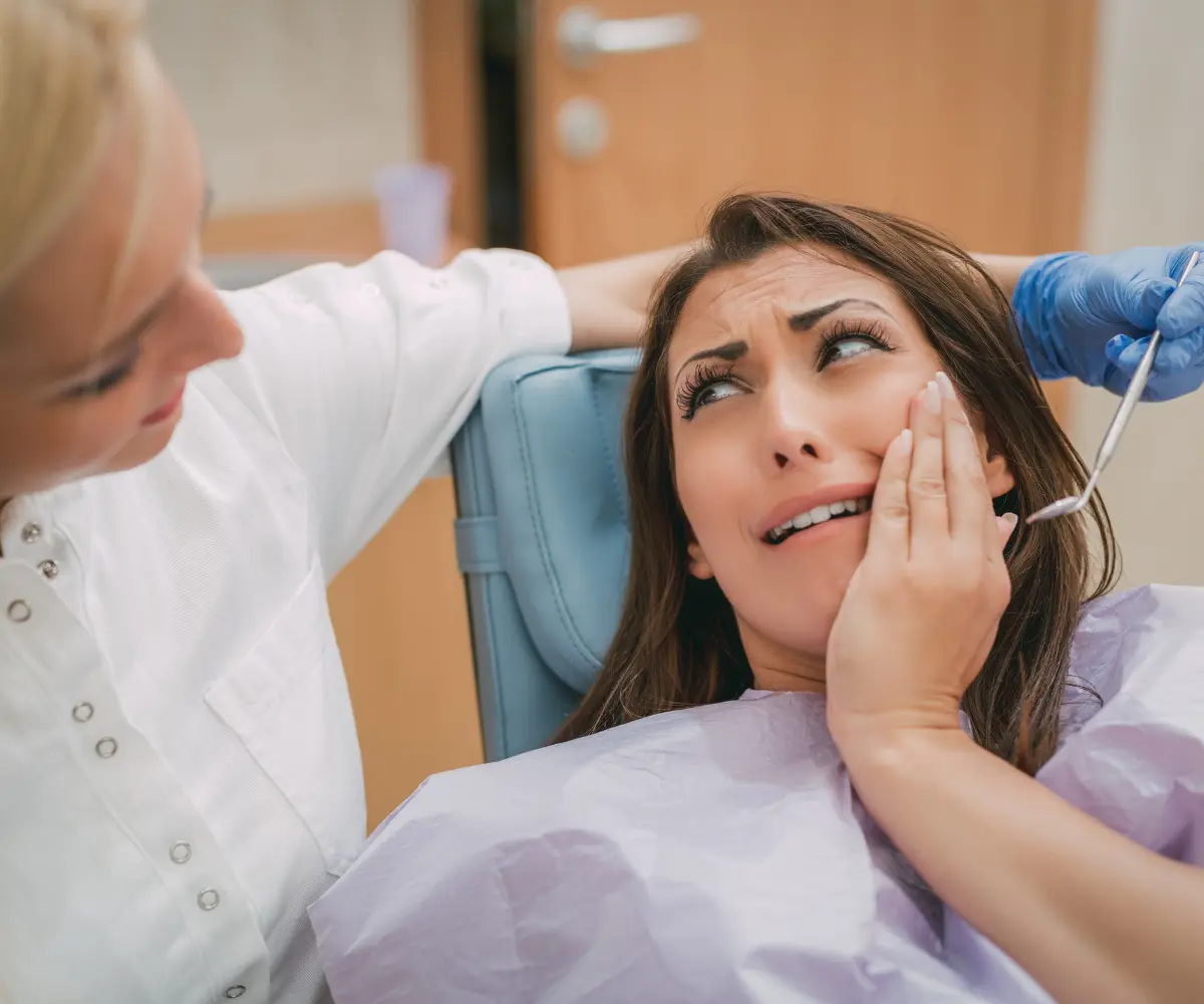 Dental professional assessing a patient after a crown has come off during an emergency appointment
